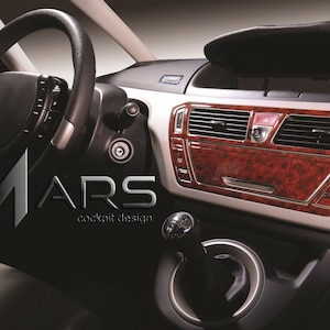 May include: Interior car detail featuring a black steering wheel, dashboard, and gear shift. The dashboard has a wood grain finish with silver trim. The text "MARS cockpit design" is visible in the image.