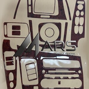 May include: A set of dark brown wood grain patterned dashboard trim decals for a vehicle interior. The glossy adhesive pieces are arranged on a backing sheet, featuring various cutouts for buttons, vents, and displays, with the text MARS cockpit design.