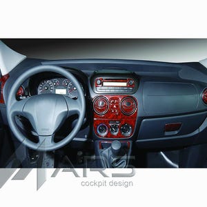 Peut inclure: Un intérieur de tableau de bord de véhicule avec un volant, un combiné d'instruments et une console centrale gris foncé. La console et les bouches d'aération sont ornées d'une garniture en bois rouge brillant. Le texte MARS cockpit design est visible.