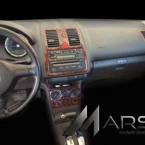 Peut inclure: Tableau de bord de voiture avec volant noir, jauges et console centrale. La console comprend une radio, des bouches d'aération et des commandes avec des garnitures en imitation bois. Le tableau de bord porte le texte "MARS cockpit design".