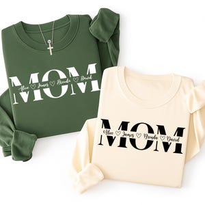 May include: A white ceramic mug with a black handle and the text "But First, Coffee" in a black, bold font. The mug is on a white surface. The mug is approximately 4 inches tall.