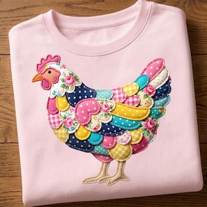 Peut inclure: Un sweat-shirt rose clair orné d'un motif de poulet patchwork coloré. Le poulet est composé de divers tissus à motifs, notamment des pois, des imprimés floraux et du vichy. Le design comprend un bec orange et une crête rose.