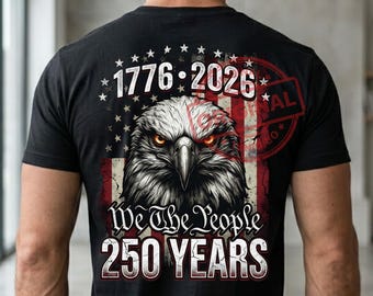 May include: A black t-shirt featuring a graphic on the back with a bald eagle head centered over a distressed American flag. The text reads 1776-2026, We The People, and 250 YEARS in white lettering. The eagle has intense orange eyes and grey feathers.