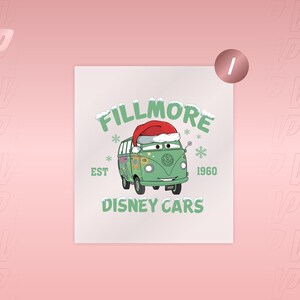 May include: A graphic print featuring Fillmore from Disney Cars, a light green van with a smiling face, wearing a red and white Santa hat. The text reads FILLMORE, EST 1960, and DISNEY CARS in green, surrounded by white snowflakes on a light background.