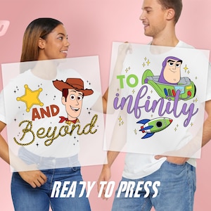 May include: Two white t-shirts featuring graphic prints. One shirt displays a cartoon cowboy, a yellow star, and the text AND Beyond. The other shirt shows a space ranger character in a ship, a rocket, and the text TO infinity. READY TO PRESS.