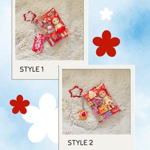 May include: Two polaroid-style photos showcase miniature doll keychains. Each keychain features a doll in a red outfit, packaged with snacks. One keychain has a red tag with Japanese text. The background is a fluffy white surface.