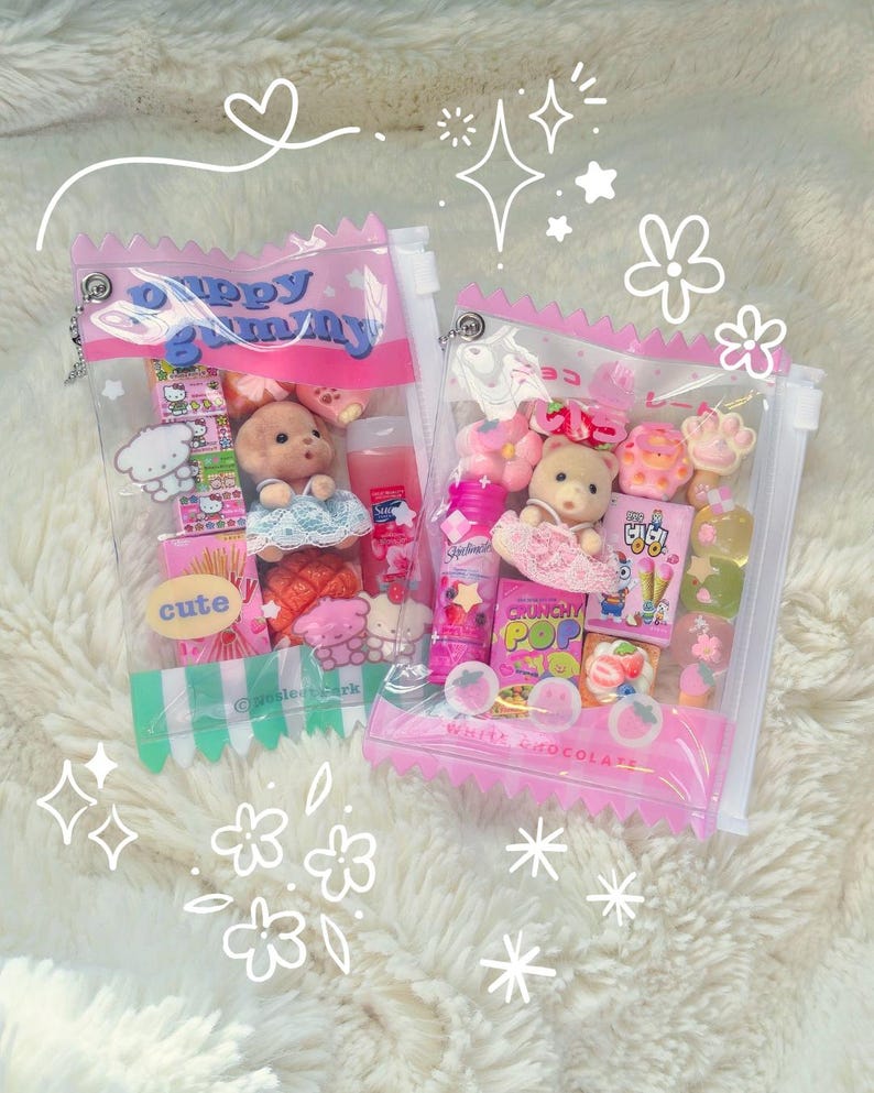 May include: Two clear, pink-trimmed pouches filled with assorted miniature toys and candies. One pouch features a teddy bear, the text "Puppy Gummy", and the word "cute". The other pouch contains a teddy bear, candies, and the text "Crunchy Pop".