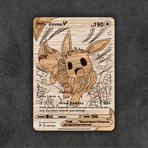 May include: Wooden Eevee V Pokémon card with engraved details. The card features the text "BASIC Eevee V", "HP 190", and "Brave Buddies". The illustration shows Eevee in a dynamic pose, surrounded by floral and abstract design elements.