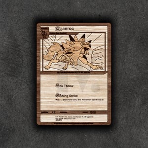 May include: Wooden laser-cut card featuring a detailed illustration of a wolf-like creature, with the name "anroc" at the top. The card includes attack descriptions and other game details, all etched into the wood. The card is rectangular with a dark border.