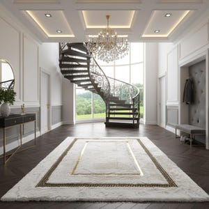 Könnte beinhalten: Ein eleganter Eingangsbereich mit einer geschwungenen Wendeltreppe und einem großen, rechteckigen weißen Teppich mit goldenen und schwarzen Bordüren. Der Raum verfügt über einen Kronleuchter, dunkle Holzböden und eine Konsole.