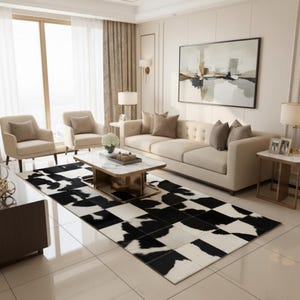 May include: A living room scene featuring a black and white cowhide rug, a beige sofa, two armchairs, and a marble-topped coffee table. The room is decorated in neutral tones with a large abstract painting on the wall.