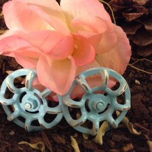 May include: A pink and white feather hair comb with a pink fabric bow. The comb is worn on a mannequin with blonde hair.