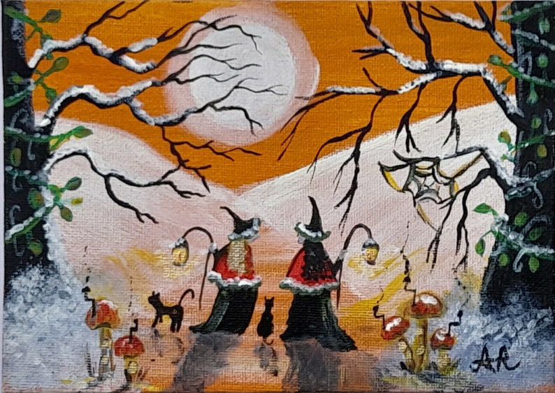 May include: Acrylic painting of two witches in black robes and hats, each holding a lantern, walking with black cats. The background features an orange sky, a full moon, and bare tree branches. Mushrooms and a spider web are also visible.