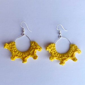 May include: A pair of yellow crocheted hoop earrings with silver hooks.