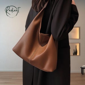 Peut inclure: Un sac à bandoulière en cuir marron avec un design incurvé. Le sac a une seule sangle et un intérieur spacieux. Le sac est en cuir lisse et texturé et a un design minimaliste. Le sac est de couleur neutre et peut être utilisé au quotidien.