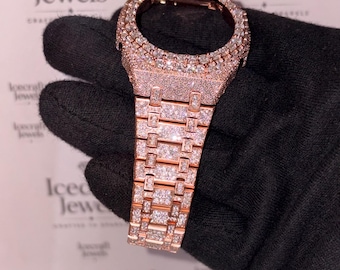 May include: A rose gold watch case and integrated link bracelet featuring a pavé setting of numerous small clear stones covering the entire surface. The watch bezel is circular, and the bracelet consists of rectangular links with a metallic finish.
