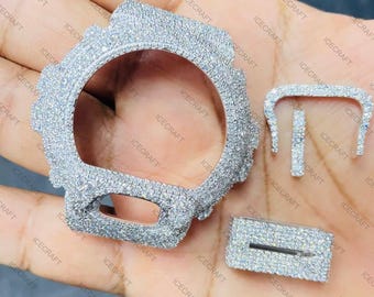 Könnte beinhalten: Ein silberfarbenes Uhrengehäuse und Armbandteile, besetzt mit zahlreichen kleinen, glitzernden Steinen. Die Teile sind auf einer Hand angeordnet und zeigen das detaillierte Design des Uhrenzubehörs. Das Gehäuse hat etwa 4 cm Durchmesser.