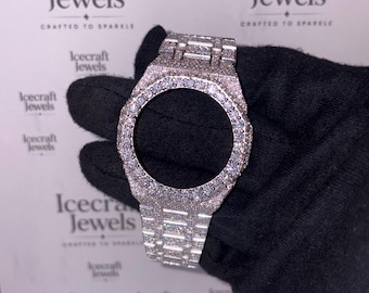 Könnte beinhalten: Ein silberfarbenes Uhrengehäuse, das mit kleinen, funkelnden Edelsteinen besetzt ist. Das Gehäuse wird von einer behandschuhten Hand gehalten, mit dem Logo "Icecraft Jewels" und dem Schriftzug "Crafted to Sparkle" im Hintergrund.