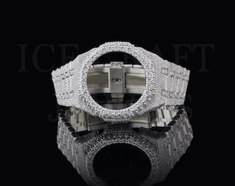 May include: A silver-toned watch case and bracelet set completely covered in small, clear, sparkling stones. The octagonal bezel surrounds a hollow center, and the metal band features a link design. The text ICE CRAFT JEWELS is visible.