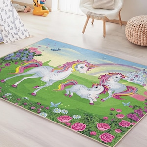 Può includere: Un tappeto rettangolare per bambini con una scena fantastica di tre unicorni bianchi con criniere e code rosa e gialle, un arcobaleno e un castello. Il tappeto ha un campo verde con fiori rosa e viola e un cielo blu.