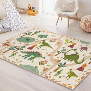 May include: A rectangular children's rug with a dinosaur theme. The rug features a cream-colored background with a road design and illustrations of various dinosaurs, trees, and volcanoes in green, brown, and red. The rug is placed on a light-colored wooden floor.
