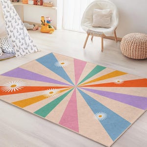 May include: A rectangular rug with a retro design. The rug features a sunburst pattern with alternating rays of orange, pink, purple, blue, and green. White daisy flowers are scattered across the rug. The rug is suitable for a child's room.