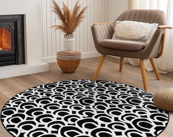 Pode incluir: Um tapete redondo com um padrão abstrato repetido em preto e branco. O tapete está sobre um chão de madeira, com uma lareira, uma cadeira e uma mesa lateral ao fundo. O diâmetro do tapete é de aproximadamente 152 cm.