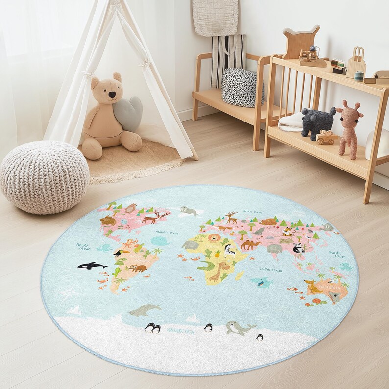 May include: A round, light blue children's rug featuring a world map design. The map includes continents in pink, green, and yellow, with illustrations of animals and landmarks. The rug has a light blue border and is placed in a child's room.