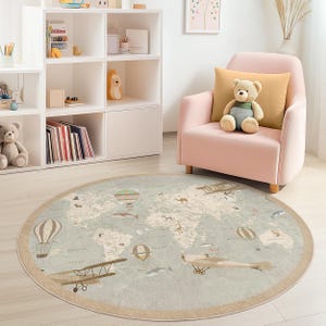 May include: A round, light blue rug with a world map design. The rug features illustrations of airplanes, hot air balloons, and animals. The rug has a beige border and is placed in a child's room with a pink armchair and white shelves.