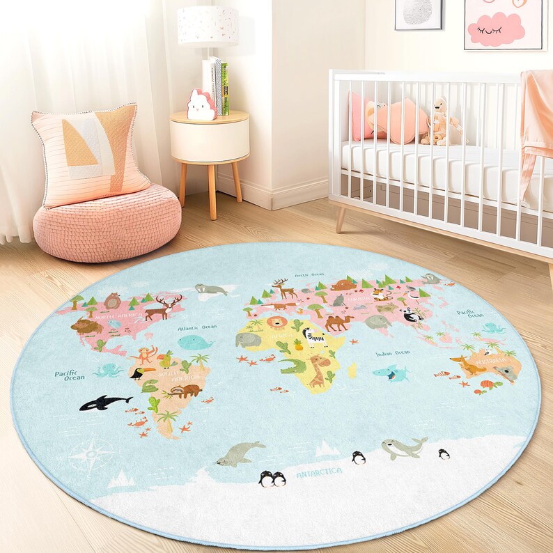 May include: A round, light blue children's rug featuring a world map design. The map includes continents in pink and green, with illustrations of animals and ocean life. The rug is placed on a wooden floor in a nursery setting.