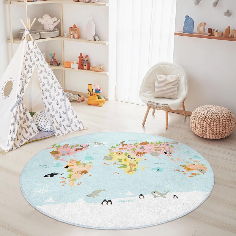 May include: A round, light blue children's rug featuring a colorful world map design with continents and animals. The rug has a white border and is placed on a light wood floor. A play tent and chair are in the background.