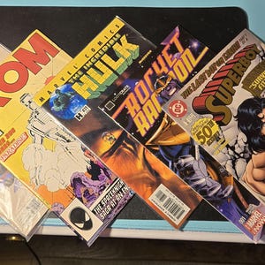 Puede incluir: Una colección de cómics de Marvel, incluyendo "Guardians of Infinity", "ROM", "The Incredible Hulk", "Rocket Raccoon" y "Superboy". Los cómics presentan colores vibrantes e ilustraciones dinámicas, mostrando temas clásicos de superhéroes.