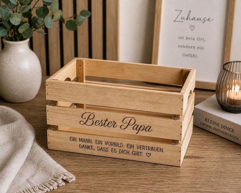 May include: A rectangular light brown wooden crate with open slats. The front panel features the engraved text Bester Papa, followed by the German phrase Ein Mann. Ein Vorbild. Ein Vertrauen. Danke, dass es dich gibt. with a small heart symbol.