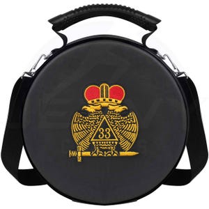 Op de afbeelding: Zwarte ronde tas met een handvat aan de bovenkant en een schouderriem. De tas heeft een goud en rood embleem met een kroon, vleugels en het nummer 33. De tas heeft zilverkleurige metalen hardware.