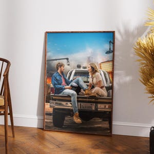 Può includere: Una stampa incorniciata raffigura una coppia seduta sul retro di un camioncino. L'uomo indossa una giacca di jeans e jeans, la donna un completo beige. Lo sfondo mostra una scena infuocata e un cielo blu.