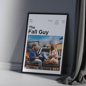 Può includere: Poster cinematografico incorniciato per "The Fall Guy" con bordo nero. Il poster presenta due persone sedute sul retro di un camion. Il poster include l'anno 2024, il titolo del film e altri dettagli.