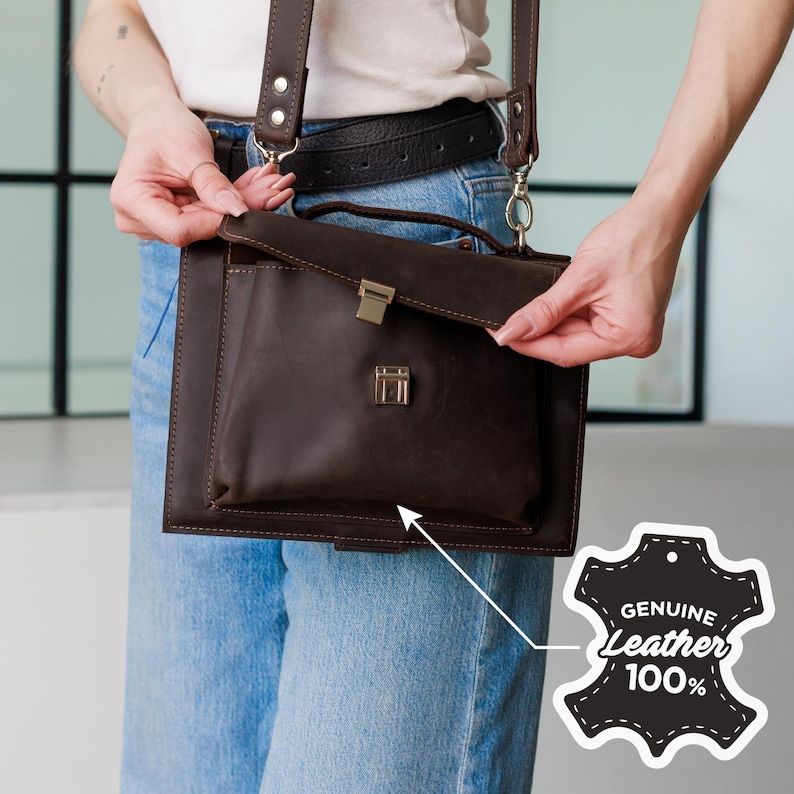 May include: A dark brown leather crossbody bag with a rectangular shape and a flap closure. The bag has a front pocket and a shoulder strap. The image includes a tag that says "GENUINE Leather 100%"