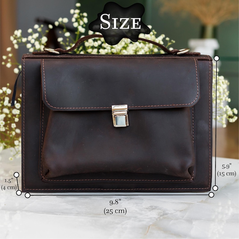 May include: A dark brown leather satchel with a front flap and a silver clasp. The bag measures 9.8 inches (25 cm) wide, 5.9 inches (15 cm) high, and 1.5 inches (4 cm) thick. The word "SIZE" is displayed above the bag.