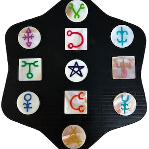 May include: A black, shield-shaped board with inlaid mother-of-pearl tiles. Each tile features a different colorful symbol, including stars, wrenches, and geometric shapes. The symbols are in shades of green, red, purple, blue, and yellow.