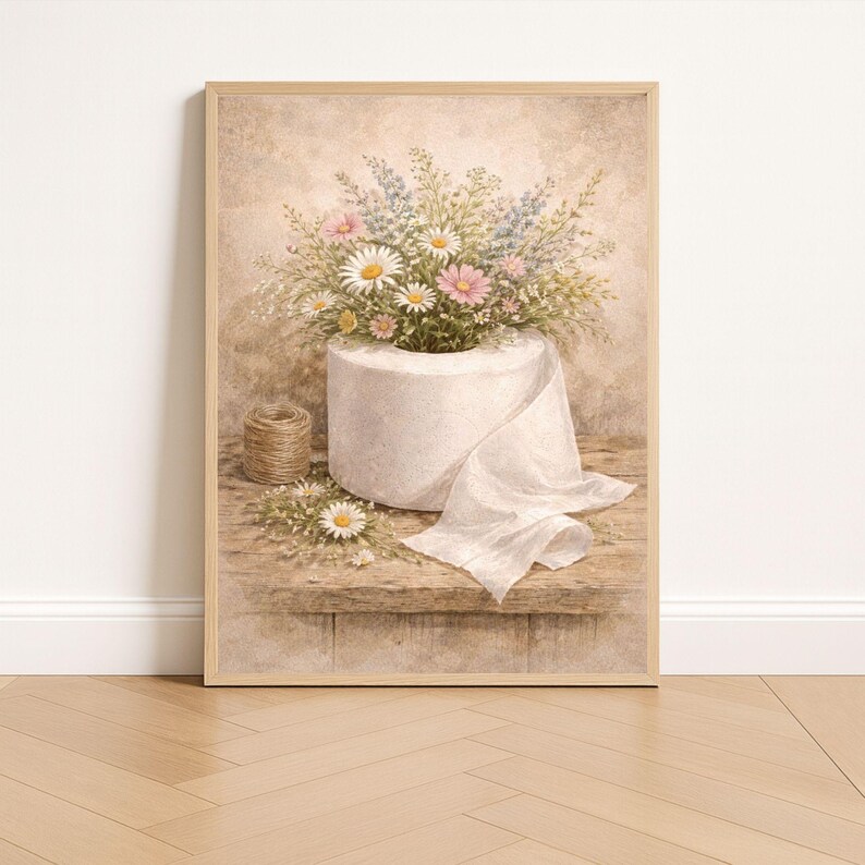 Puede incluir: Impresi&oacute;n enmarcada que muestra un rollo de papel higi&eacute;nico blanco desbordante de margaritas, flores silvestres rosas y azules. Una peque&ntilde;a bola de hilo y algunas flores sueltas est&aacute;n sobre una superficie de madera. Est&eacute;tica vintage.