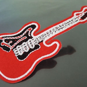 May include: Red embroidered iron-on patch of an electric guitar with white and black details.