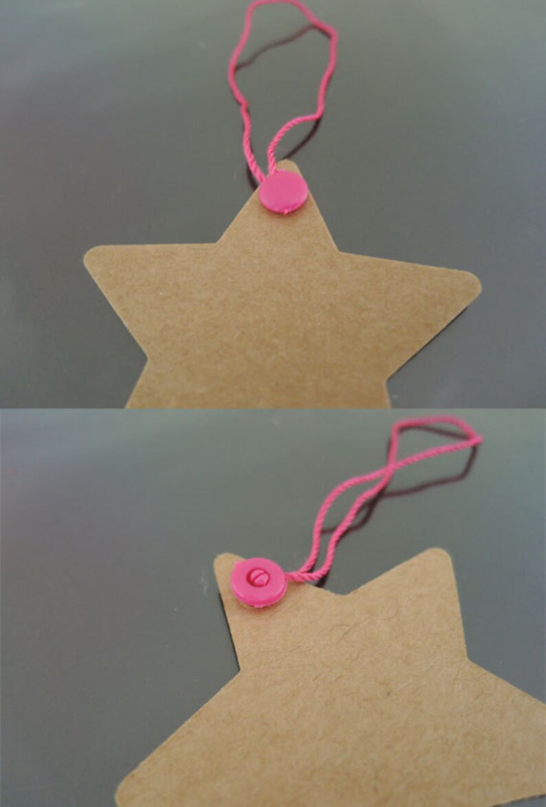 May include: A brown star-shaped paper tag with a pink plastic button and a pink string attached.