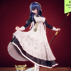 Pu&ograve; includere: Statuetta dettagliata di un personaggio in costume da cameriera, con un vestito bianco con finiture nere e motivi floreali. La figura ha i capelli blu e tiene in mano un bastone. La base include un piccolo secchio e una scopa. Il testo "Maid Kronii Hololive" &egrave; visibile.