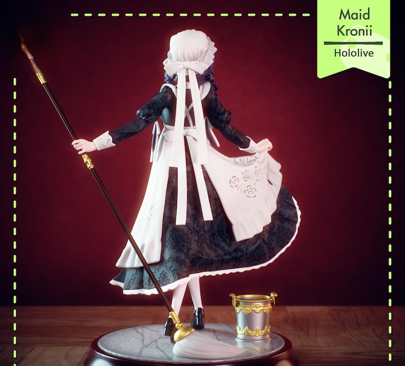 Pu&ograve; includere: Statuetta di una cameriera, con un vestito bianco e nero, grembiule e cuffia, che tiene una lancia. Un piccolo secchio dorato &egrave; sulla base. Il testo "Maid Kronii Hololive" &egrave; su un'etichetta verde.
