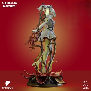 May include: A detailed figurine of a woman with white hair and a white dress, adorned with red and gold accents. The figure is surrounded by thorny vines and rests on a large, red flower base. The text "CAMELLYA JAN2025" is visible.