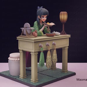 May include: A detailed figurine of a woman in a green outfit, working at a table. The table has a lamp, bowls, and a grinding stone. Decorative brooms hang below. The base is green, and the background is dark.