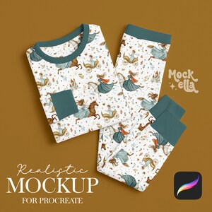 Pode incluir: Um conjunto de pijama branco com um padrão de princesa e unicórnio. A parte superior de manga comprida e as calças têm detalhes e punhos em verde-azulado. As palavras "Realistic Mockup for Procreate" estão na parte inferior.