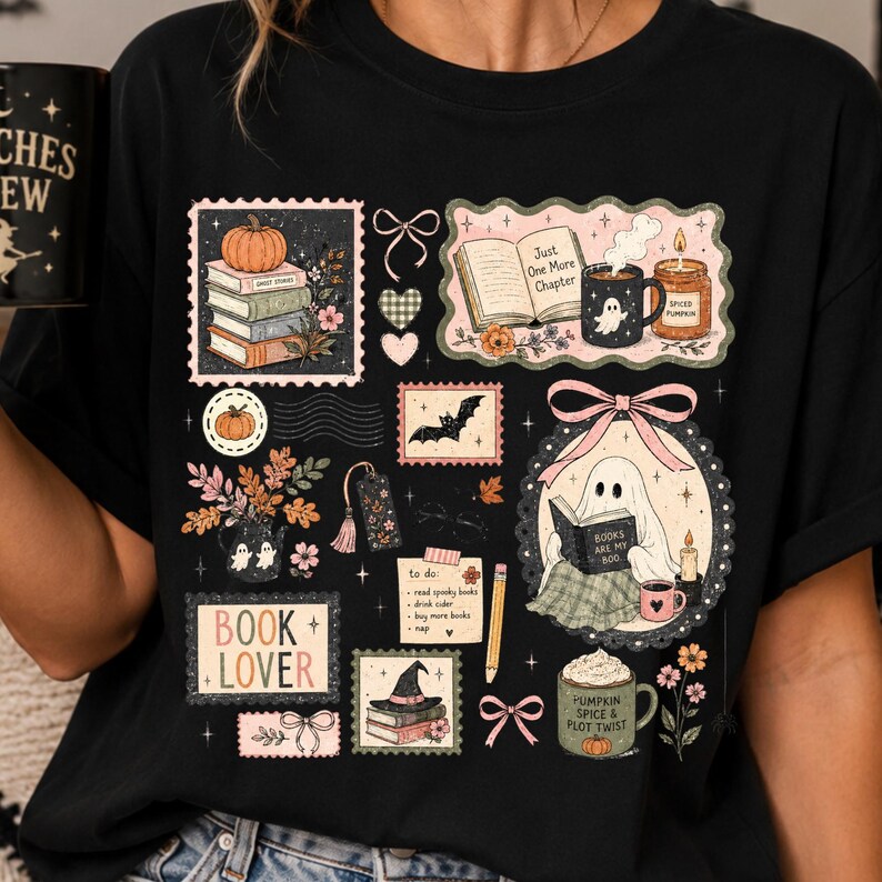 K&ouml;nnte beinhalten: Ein schwarzes T-Shirt mit einem farbenfrohen Grafikdruck verschiedener herbstlicher und buchbezogener Illustrationen, darunter ein lesender Geist, B&uuml;cherstapel, K&uuml;rbisse, eine Fledermaus, ein Hexenhut und Tassen mit Text wie Just One More Chapter.