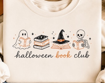 Könnte beinhalten: Ein cremefarbenes Sweatshirt mit einem Grafikdruck, der einen lesenden Geist, einen Bücherstapel, ein offenes Buch mit einem Hexenhut und ein lesendes Skelett zeigt. Der Text "halloween book club" ist darunter in Schwarz und Orange gedruckt.