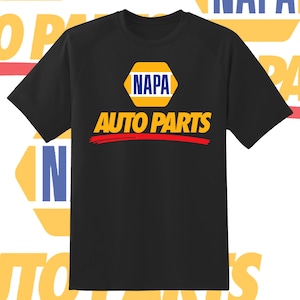 May include: Black t-shirt featuring the NAPA Auto Parts logo. The logo is a yellow hexagon with the word "NAPA" in blue, and "AUTO PARTS" in yellow with a red underline. The shirt is a classic crew neck.